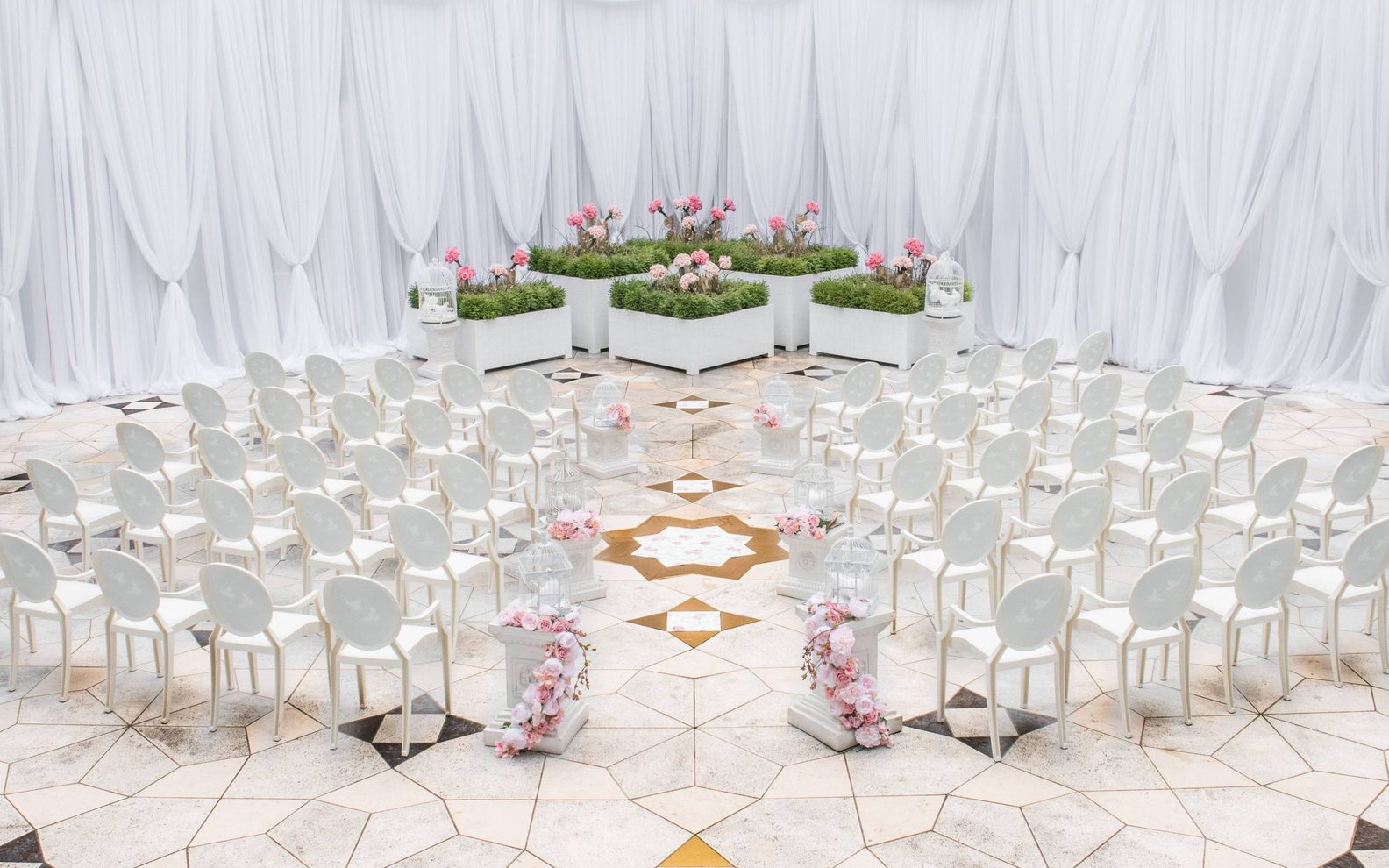 Wedding ceremony set up with white chairs on a decorative tile floor at the Aga Khan Museum