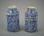 Two blue patterned ceramic pharmacy jars with a large body and tapered opening. Patterns include flowers, vines, fruits and other cymbals.